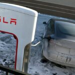 A Tesla vehicle charges in a salt and ice covered parking lot on January 17, 2024 in Chicago, Illinois.