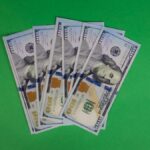 100 dollar bills on a green background