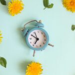 Alarm clock over a blue background symbolizing DST.