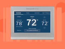 A smart thermostat on a red-orange background.