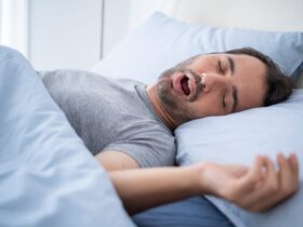 Man snoring while sleeping on bed.